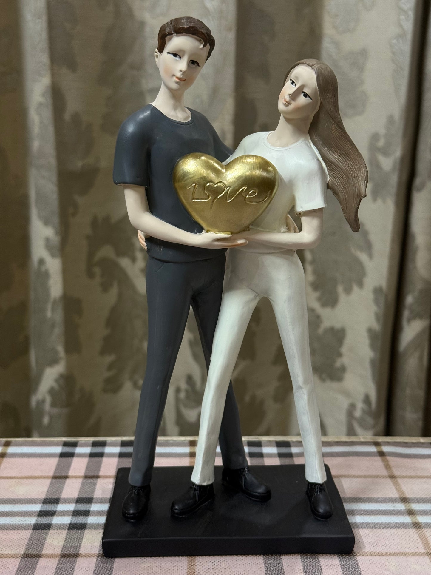 Together in Love – Couple Holding Golden Heart Figurine